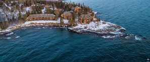 A lodge with multiple cabins on a snow-covered island, surrounded by water and trees. - Lake Superior Retreat Near Two Harbors; Waterfront Views + Access; Cozy getaway! (Two Harbors)