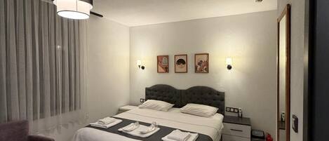 A modern bedroom with a bed, bedside tables, a chair, and a hanging light fixture.
