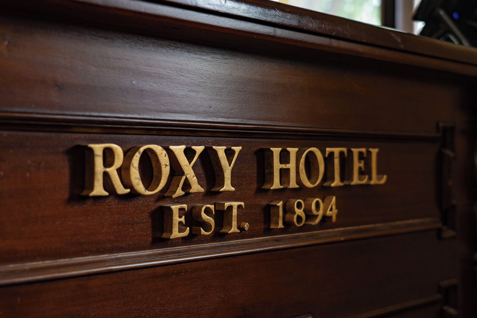 A wooden sign with the text "ROXY HOTEL EST. 1894".