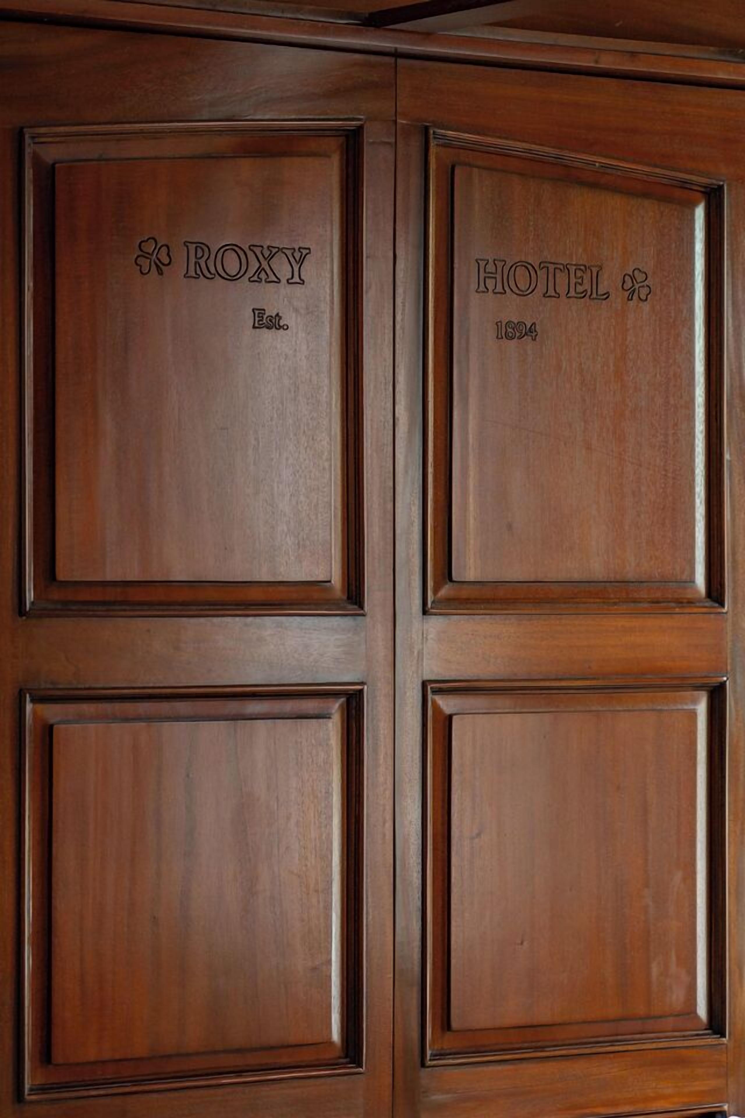 A wooden door with the name "ROXY" and "HOTEL" along with the year "1824" engraved on it.
