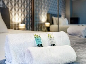 A neatly made bed with white towels and two bottles of Mason & Miller shower gel. - City Centre | Cityscape & Sunset Views - Pass the Keys (Belfast)