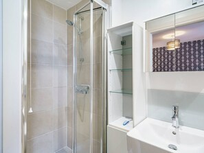 A modern bathroom with a glass-enclosed shower, a white sink, and a mirror with a geometric-patterned backsplash. - City Centre | Cityscape & Sunset Views - Pass the Keys (Belfast)