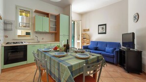 A compact living space with a dining area, kitchenette, and a seating area with a television. - 4025 Casa di Tina by Barbarhouse (Melendugno)