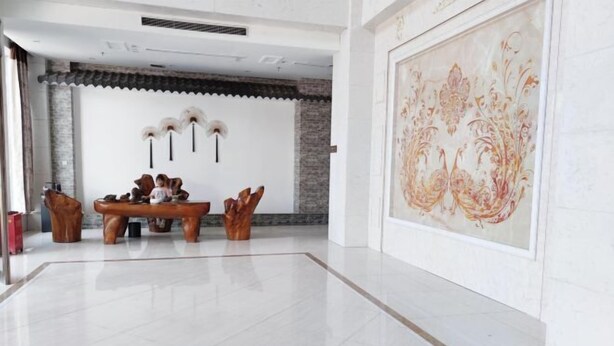 Una habitació espaiosa amb taula i cadires de fusta tradicional, un gran quadre decoratiu i un disseny de sostre modern.