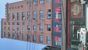 Un edifici de diverses plantes amb diversos equips de aire condicionat a la façana.
