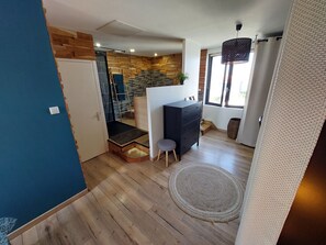 Relax in this inviting space with a bench and stool, surrounded by a woven rug and natural views.