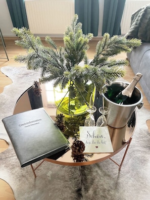 Relax in style with a glass-topped coffee table, perfect for enjoying a drink or a quiet moment with a small potted plant.