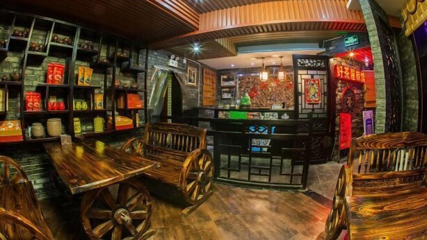 L’intérieur d’un restaurant traditionnel, avec des meubles en bois, des étagères remplies d’assiettes et un comptoir.