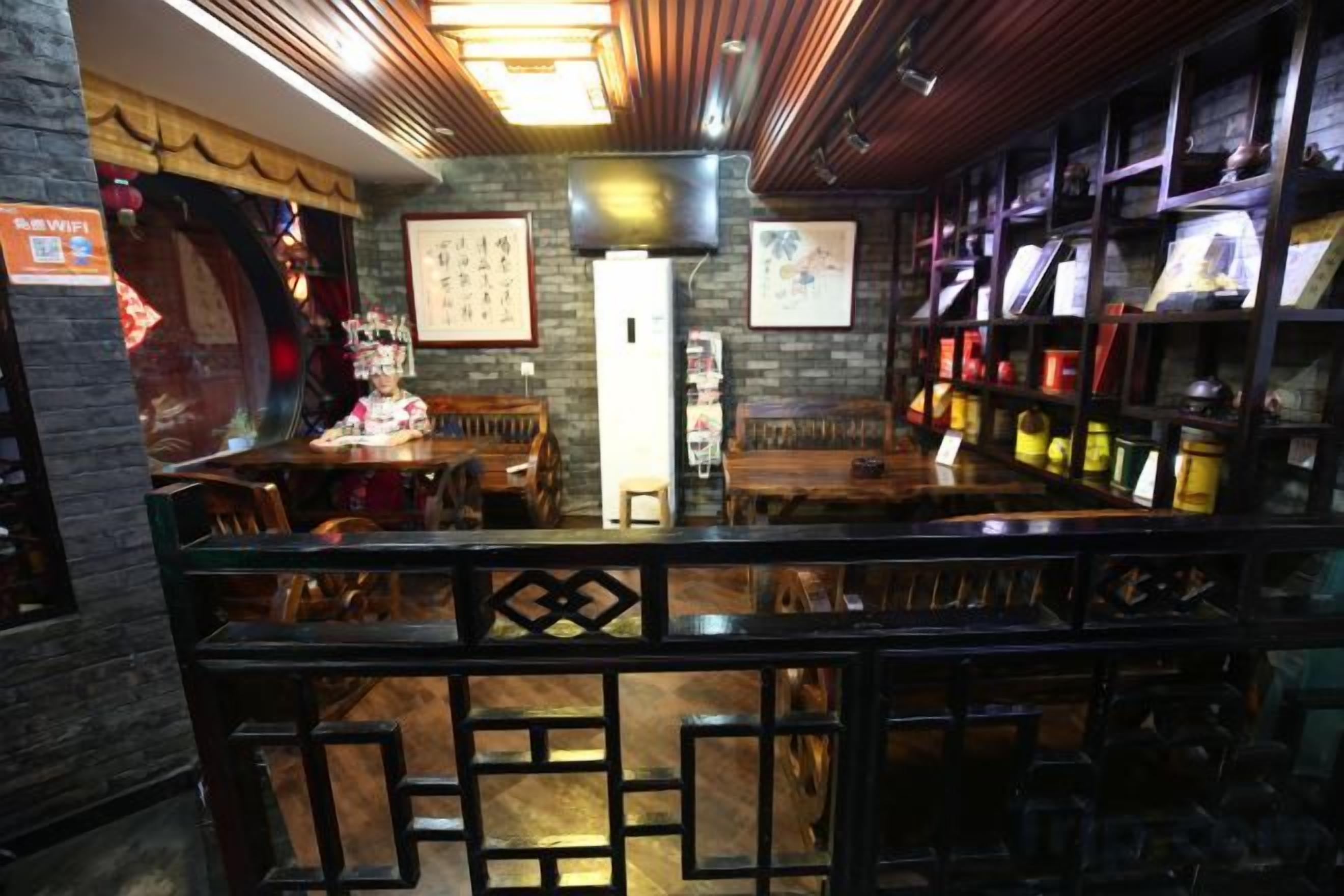 A bar area with wooden furniture, a counter, and shelves with bottles.