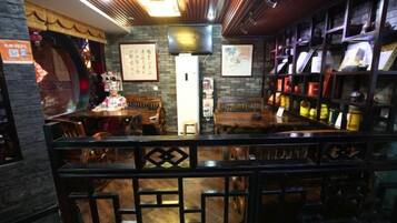 A bar area with wooden furniture, a counter, and shelves with bottles.