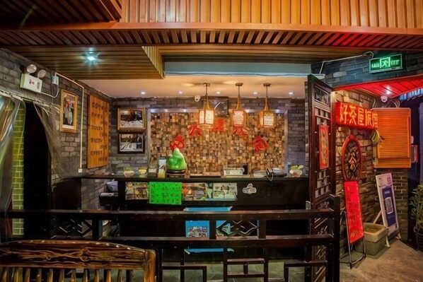 A bar area with a counter, hanging lights, and a brick wall. - Haochawu Boutique Inn (Fenghuang County)