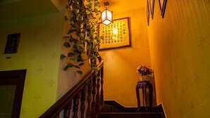 Un escalier avec des rampes en bois et un luminaire fixé au mur.