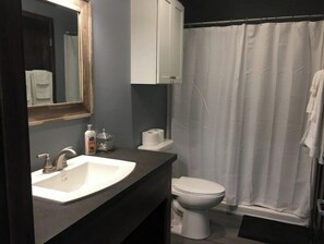 Een douche, handdoeken, zeep, toiletpapier
