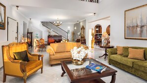 A spacious living room with a high ceiling, a staircase, and a piano. - Renko Royal Villa  Luxury villa in Athens Riviera. Private Pool,  garden & BBQ (Lagonisi)