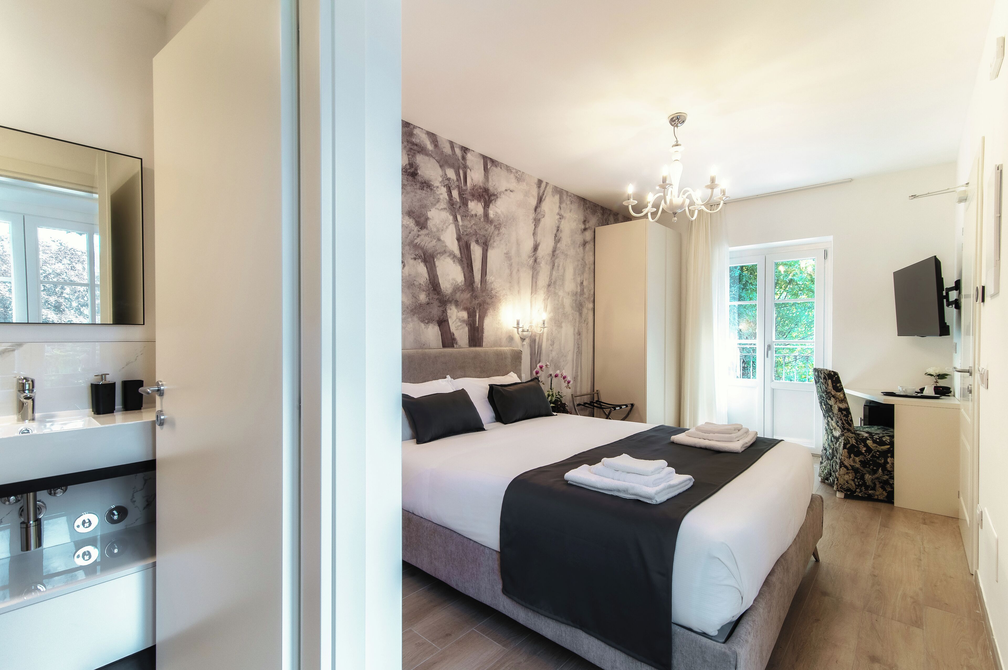 Ein modernes Schlafzimmer mit einem großen Bett, einem Frisiertisch mit Spiegel und einem Schreibtisch mit Stuhl.