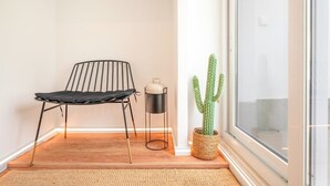 A minimalist room with a black metal chair, a small metal table, and a cactus plant. - GuestReady - A charming place to stay in Lisbon (Lisbon)