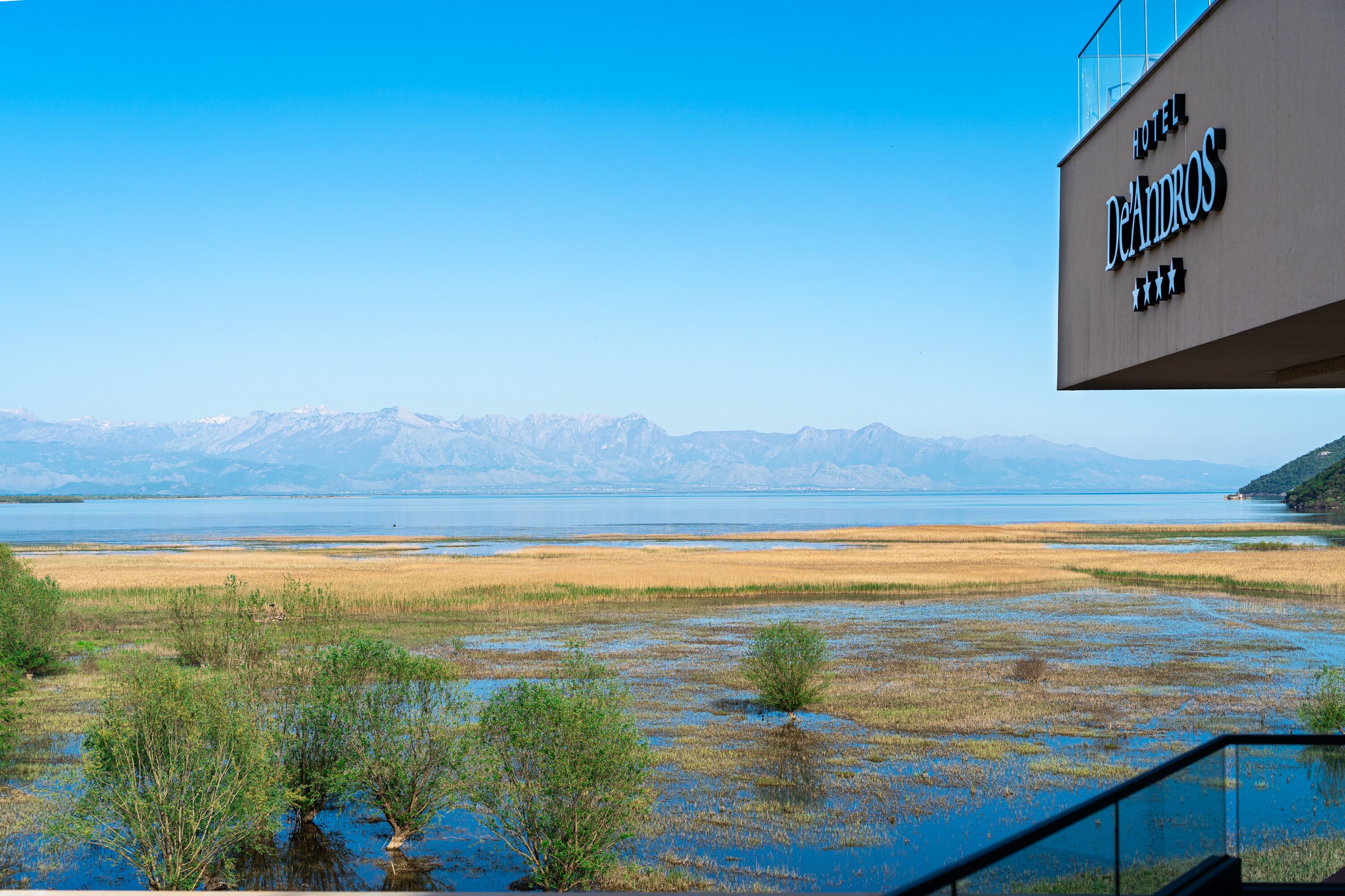 Un letrero de hotel con vistas a un lago y montañas.
