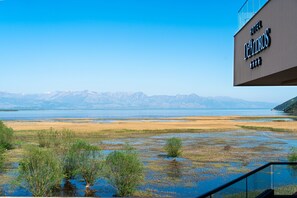 A hotel sign with a view of a lake and mountains.