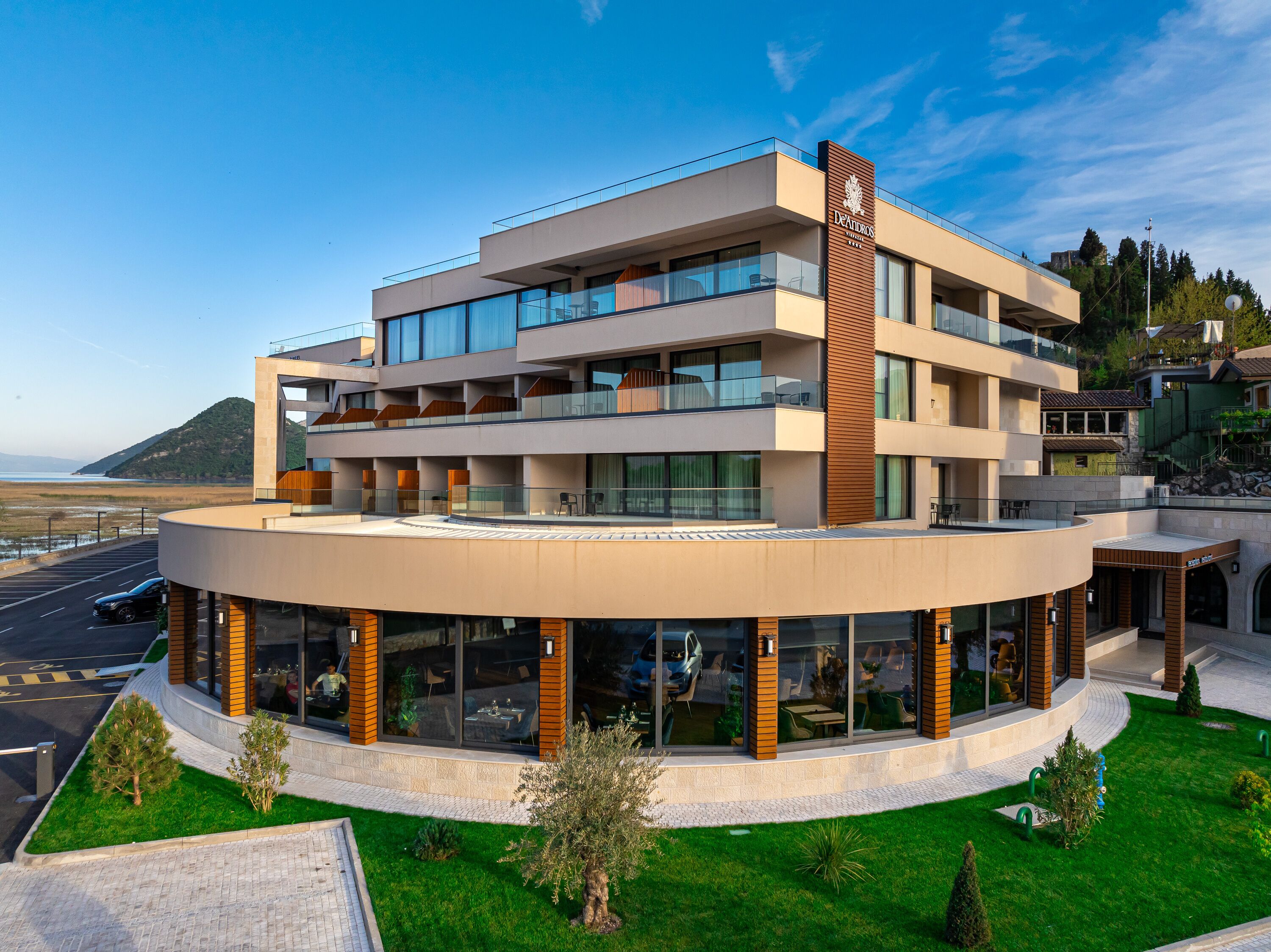 Ein modernes Hotel mit einem kreisförmigen Innenhof, mehreren Balkonen und großen Fenstern.