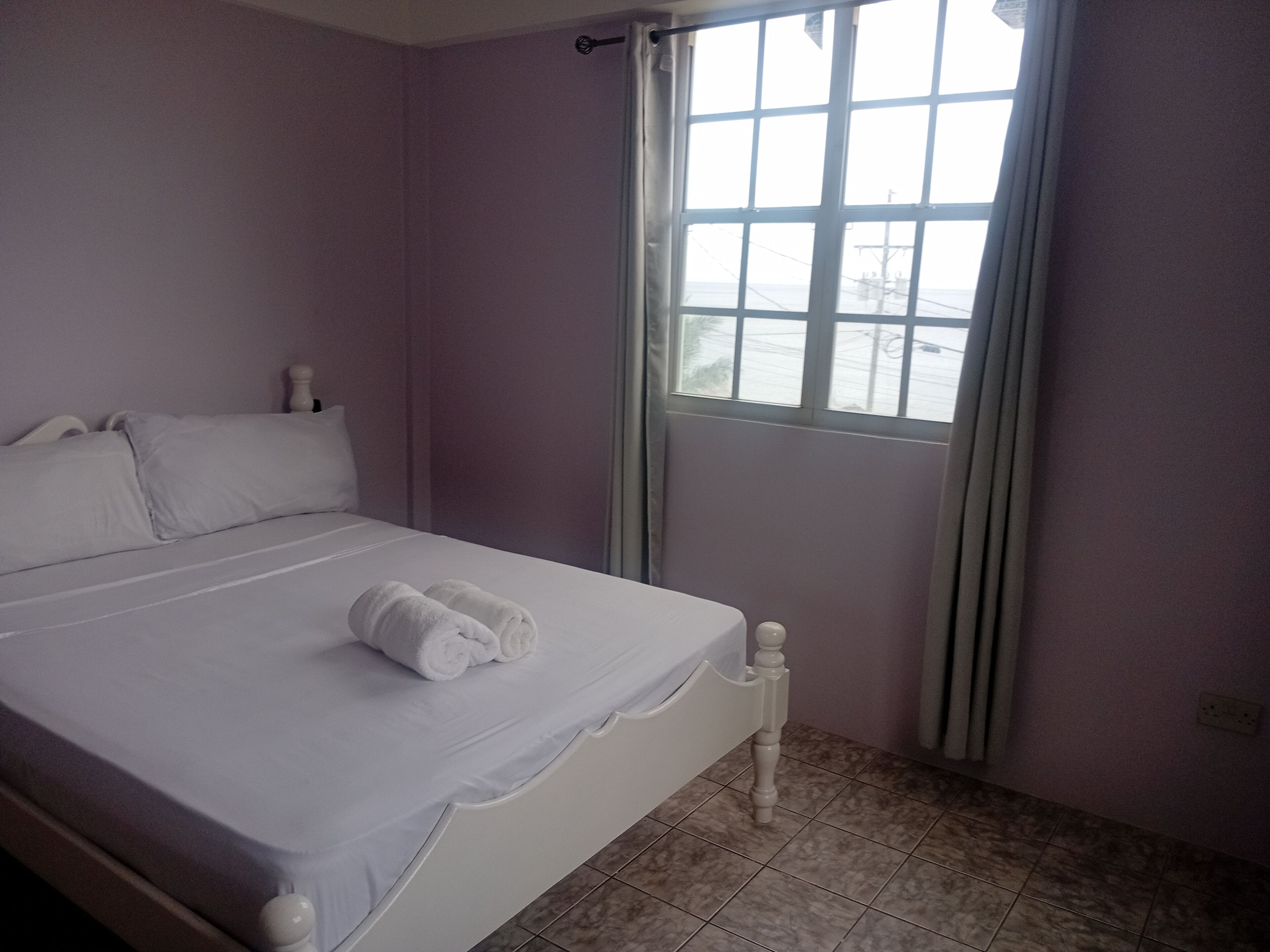 Ein Schlafzimmer mit Bett, Fenster und Nachttisch.