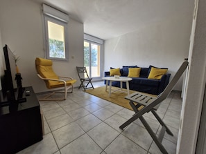 Relax in this stylish living room with a sofa, armchair, and floor lamp, offering a comfortable space for reading and entertainment.