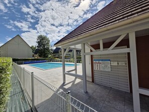 Relax by the pool surrounded by a secure fence and shaded seating area.