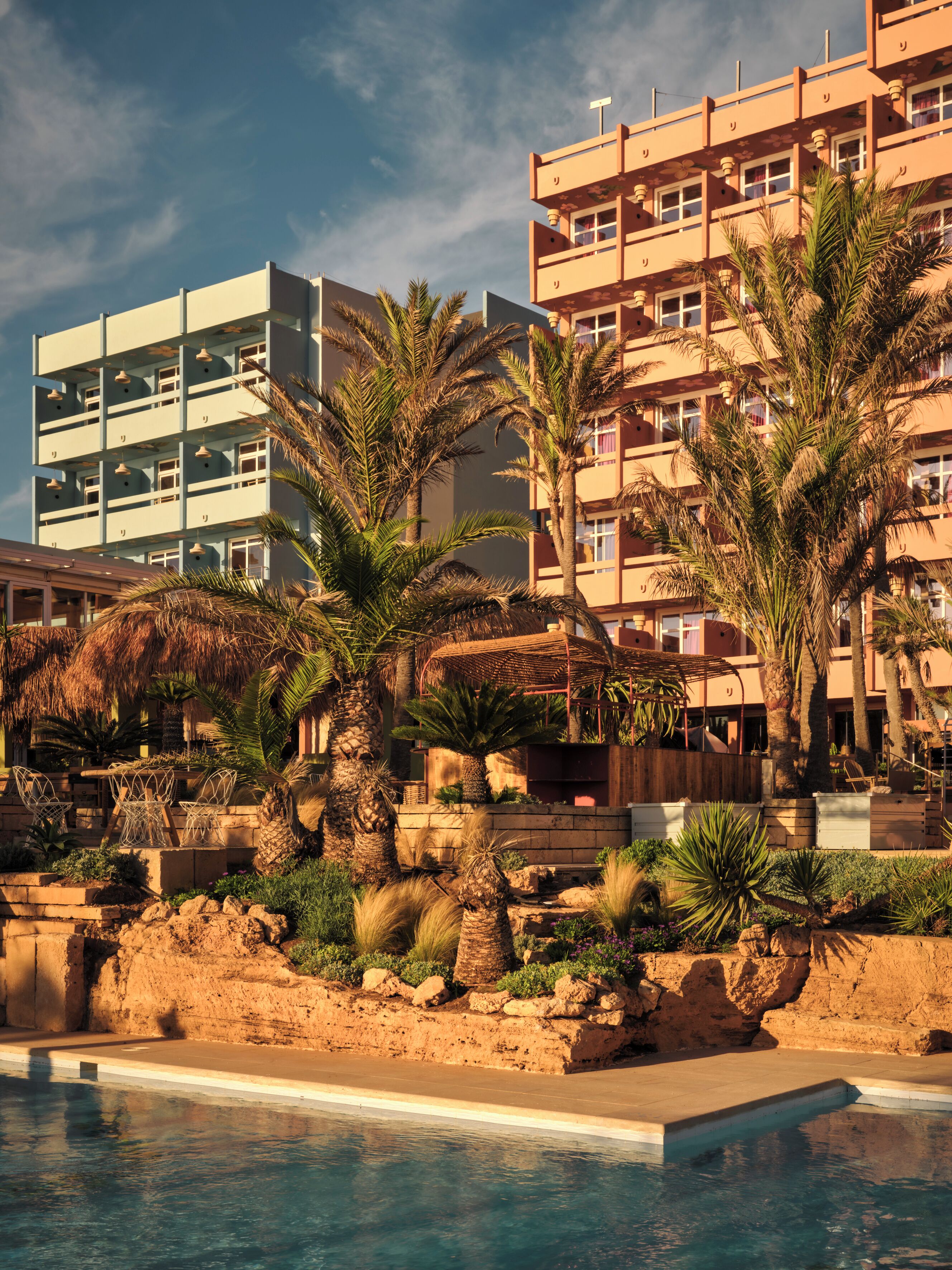 Ein Resort mit Pool, Palmen und einem Gebäude mit Balkonen.