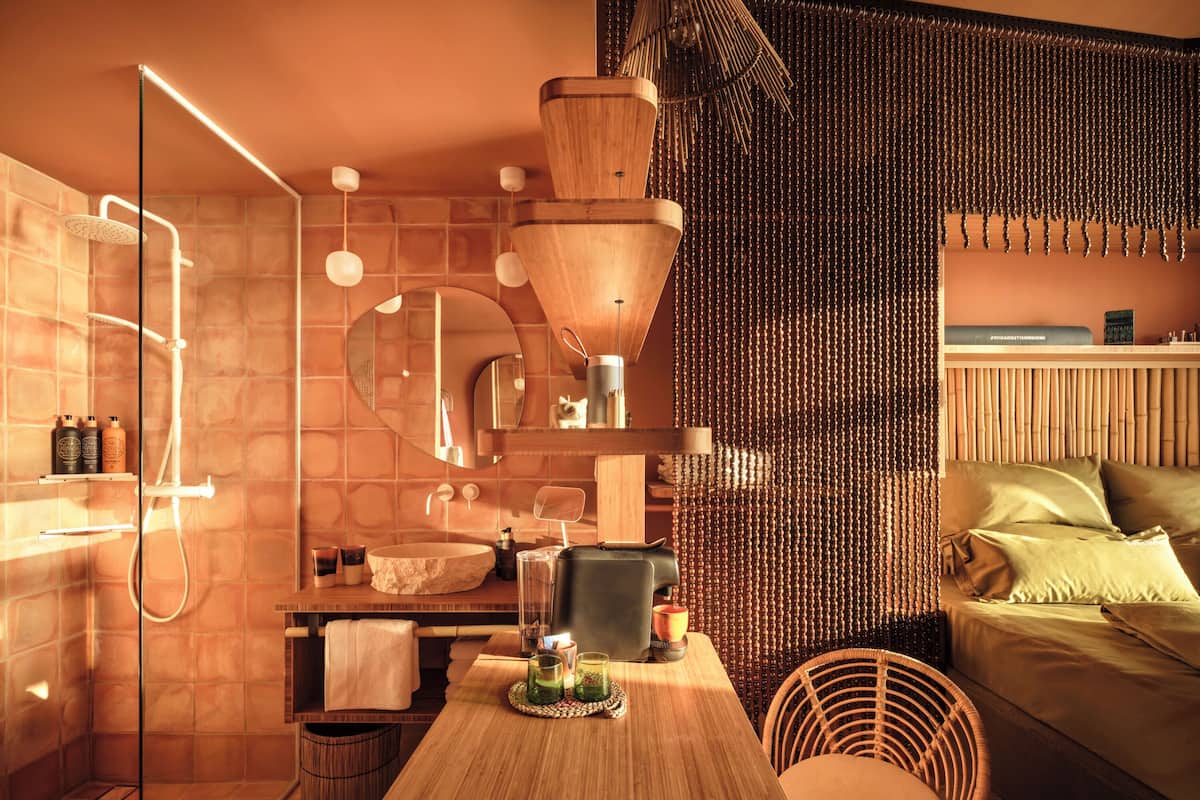 Une salle de bain moderne avec une douche à parois de verre, un meuble-lavabo en bois et un miroir rond.