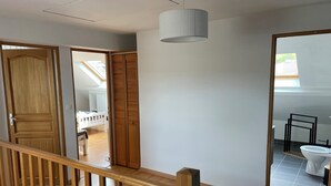 A room with a wooden door, a white ceiling, and a view of a balcony. - Maison D'hôtes (Baslieux-sous-Châtillon)