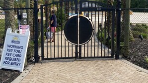 A gated entrance to The Oasis with a sign indicating a working key fob/card is required for entry. - The Wharf resort Orange Beach with Waterpark included (Orange Beach)