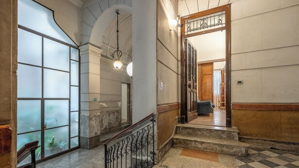 Eine prachtvolle Diele mit Schachbrettfußboden, einer Treppe mit Holzgeländer und einer großen Glastür mit Sandstrahlmuster.