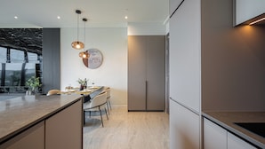 A modern kitchen with a central island, built-in appliances, and pendant lighting. - The Opera Residences (Ho Chi Minh City)