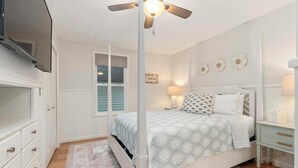 A bedroom with a bed, bedside tables, a ceiling fan, and a window with blinds. - Walk Downtown - Fall Colors, Wineries & Firepit (Boyne City)