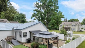 A single-story house with a patio and a covered outdoor seating area. - Walk Downtown - Fall Colors, Wineries & Firepit (Boyne City)