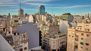 A cityscape with various buildings, including a prominent modern skyscraper and older, smaller structures. - Céntrico Studio Para 2 Personas (Buenos Aires)