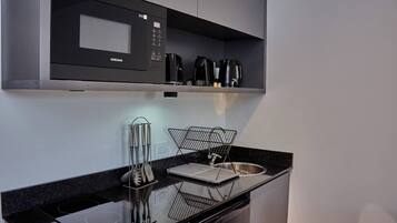 Microondas, cafetera/tetera, utensilios de cocina, mesa de comedor