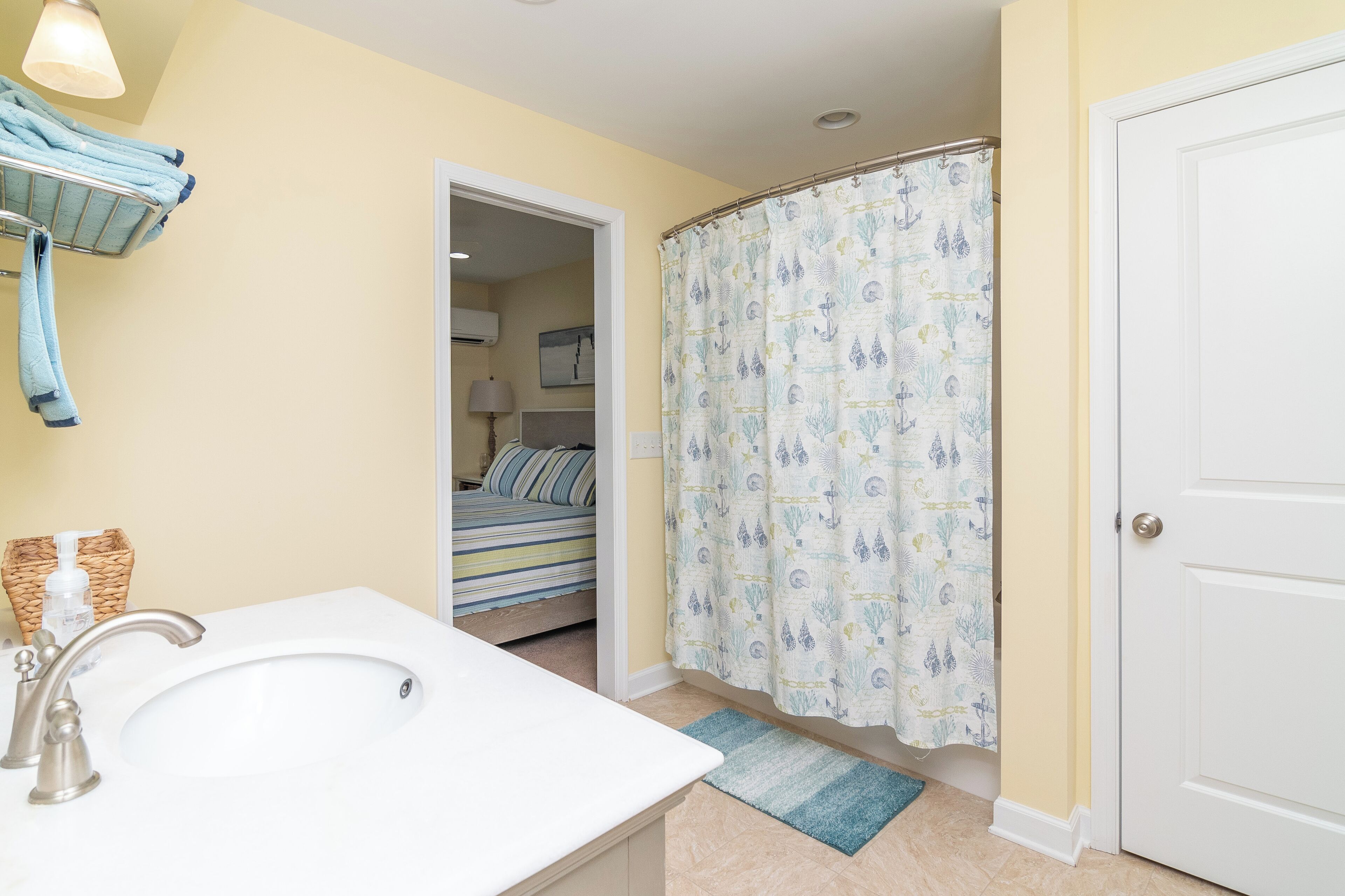 A bathroom with a sink, towel rack, and shower curtain.
