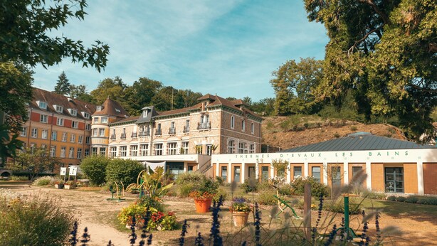 Un hotel de estilo arquitectónico europeo tradicional, con varios pisos y fachadas de ladrillo y piedra.