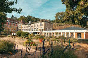 Un hotel de estilo arquitectónico europeo tradicional, con varios pisos y fachadas de ladrillo y piedra.