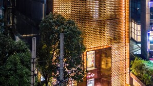 A hotel with a distinctive facade featuring a grid-like pattern of lights. - Hotel Nandini (Dhaka)
