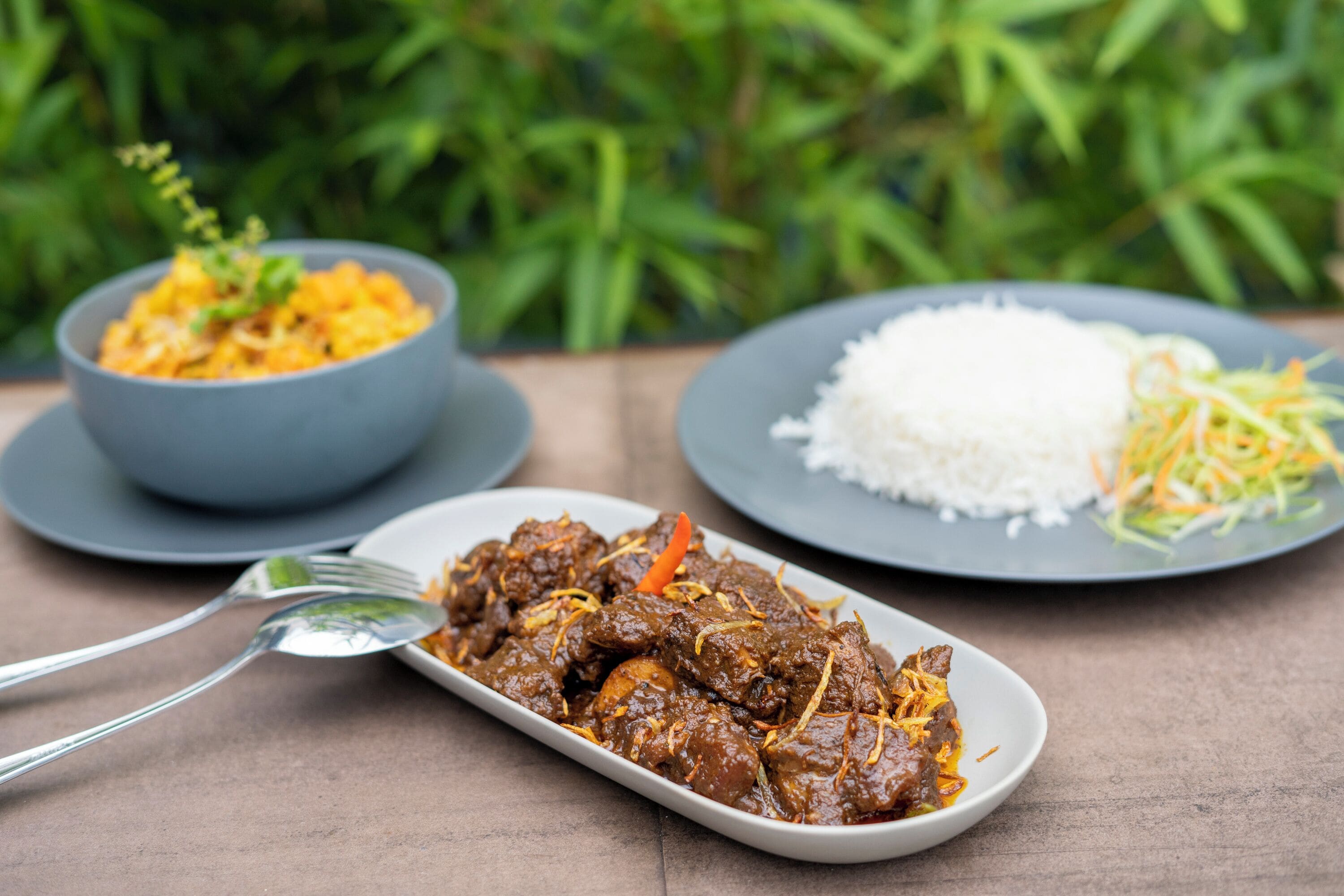 A meal with meat, rice, and vegetables on a table.
