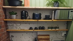 A compact kitchenette with a sink, a coffee maker, a toaster, and a small refrigerator. - A nestled retreat to create memories (Cape Town)
