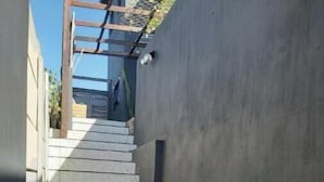 A narrow alley with a stone-paved path leading to a staircase. - A nestled retreat to create memories (Cape Town)
