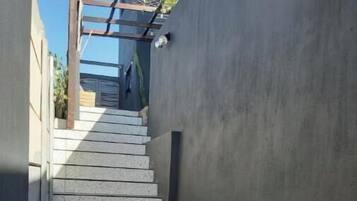A narrow alley with a stone-paved path leading to a staircase.