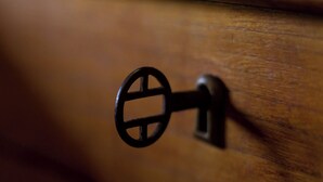 A close-up of a wooden door with a black metal handle.