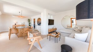 Relax in a spacious living area with a dining table, sofa, and wall-mounted TV.