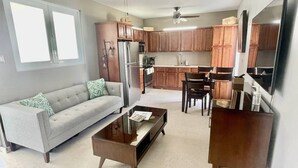 Una cocina moderna con armarios de madera, un refrigerador y un comedor con sillas y una mesa.