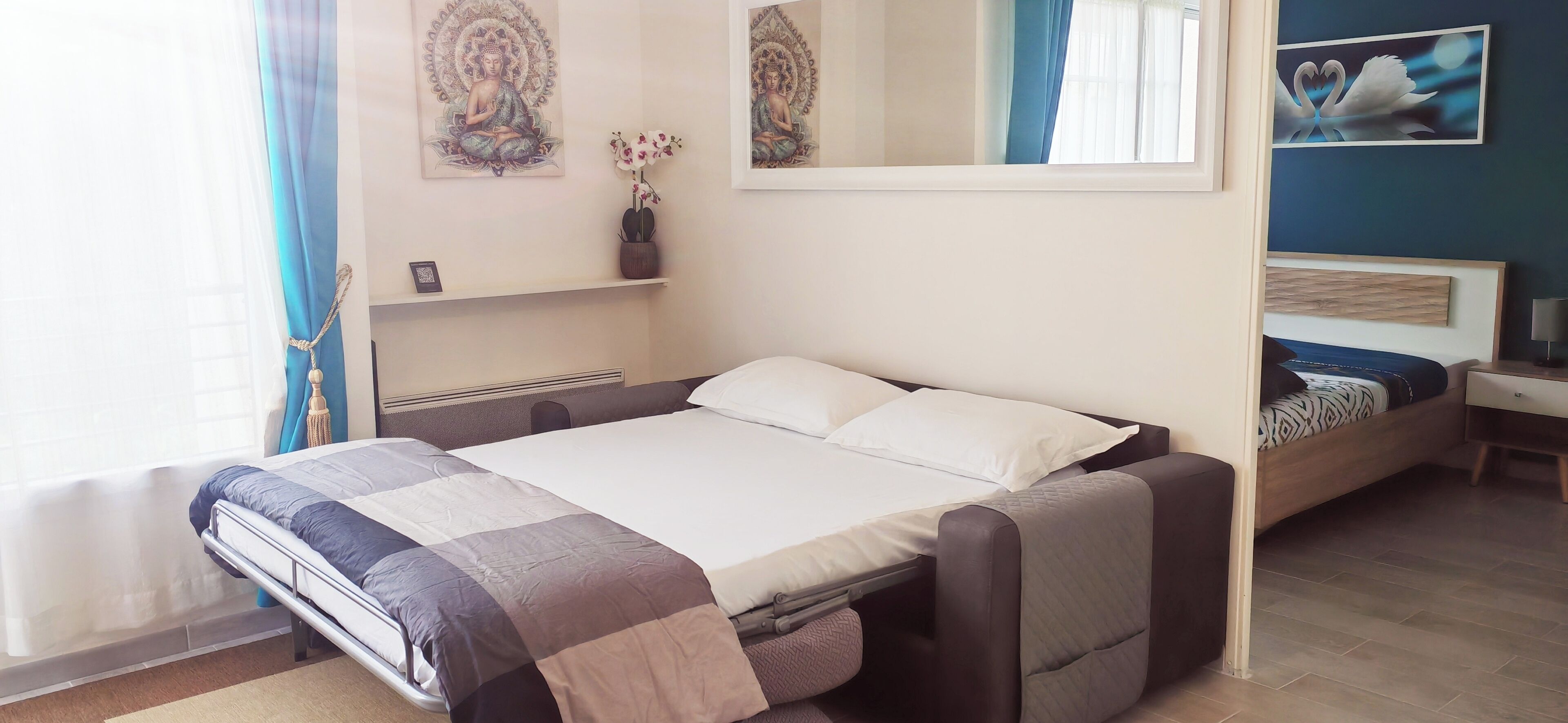 A modern bedroom with a bed, bedside tables, and artwork on the walls.