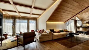A spacious living room with wooden flooring, a high ceiling, and a large sofa set. - 350 - Suite The West - Luxury residence (Courchevel)