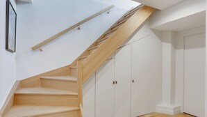 A wooden staircase with a handrail, leading to a white door. - 168 Suite M - Superb apartment in Paris (Paris 02 Bourse)